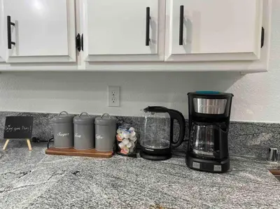 a kitchen counter with a coffee maker and a coffeemaker at Entire Modern House with King bed & 65inTV in Carmichael