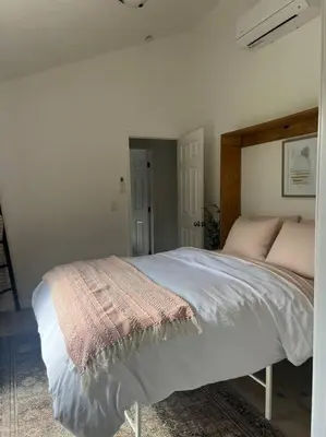 a bedroom with a large bed with white sheets and pink pillows at Modern Cabin, Near Snow Park, 3.5 Miles to SNP! in Three Rivers