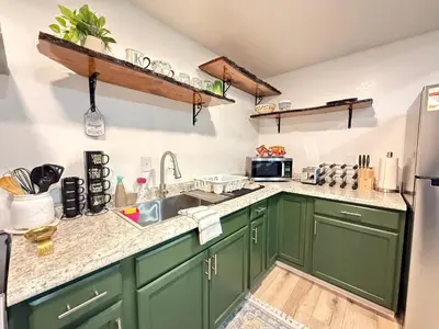a kitchen with green cabinets and a sink at Modern Cabin, Near Snow Park, 3.5 Miles to SNP! in Three Rivers