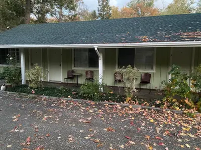a house with chairs and a porch with leaves on the ground at Seven Circles Lodge&Retreat in Badger