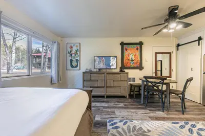 a bedroom with a bed and a desk and a table at Delightful Studio w/Kitchenette #111 at Donner Lake Village in Truckee