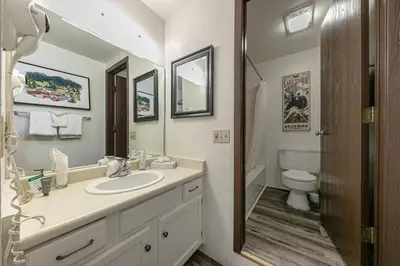 a bathroom with a sink and a toilet and a mirror at Delightful Studio w/Kitchenette #111 at Donner Lake Village in Truckee
