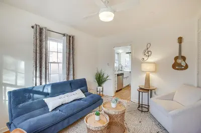 a living room with a blue couch and a chair at Less Than 1 Mi to Midtown Pet-Friendly Home in Reno! in Reno