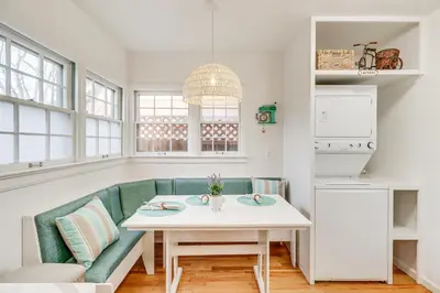 a kitchen with a white table and a green couch at Less Than 1 Mi to Midtown Pet-Friendly Home in Reno! in Reno