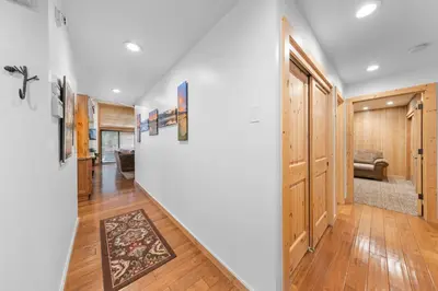 a hallway with white walls and wood floors and a staircase at Rocky Point # 14 Palisades Townhome - Ski Shuttle w Tennis! in Olympic Valley