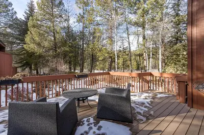 a deck with a table and chairs in the snow at Rocky Point # 14 Palisades Townhome - Ski Shuttle w Tennis! in Olympic Valley