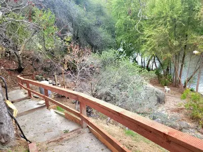 a wooden fence on the side of a hill at Retro Casita on the River! only 1 min to SNP gate! Riverfront with swimming in Three Rivers