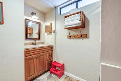 a bathroom with a sink and a red stool at Serene Cabin Retreat Between Murphys and Arnold in Murphys