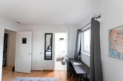 a white room with a table and a mirror at SunHouse 1410sqft BBQ 3xTVs Pets W/D Backyard in Sacramento