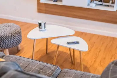 two white tables in a living room with a remote control at Arden Family Home BBQ Big Kitchen Backyard Pet W/D in Sacramento