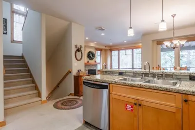 a kitchen with a sink and a staircase at Upscale 4 Bed, 3 Bath at the Woodwinds with Amazing Mountain Views and Golf Course Access and private hot tub and garage sleeps 10 in Mammoth Lakes