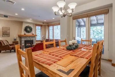 a dining room with a table and a fireplace at Upscale 4 Bed, 3 Bath at the Woodwinds with Amazing Mountain Views and Golf Course Access and private hot tub and garage sleeps 10 in Mammoth Lakes