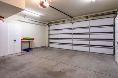 a garage with white garage doors and a table at Upscale 4 Bed, 3 Bath at the Woodwinds with Amazing Mountain Views and Golf Course Access and private hot tub and garage sleeps 10 in Mammoth Lakes