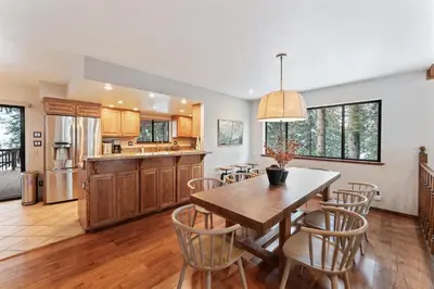 a kitchen and dining room with a wooden table and chairs at The Pinecrest Retreat- 10 mins to NorthStar! Hot Tub, Large Deck, Views, and Games in Tahoe Vista