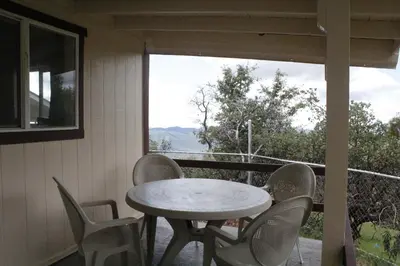 a table and chairs on a porch with a view at Hummingbird Hill - Entire Cabin in Dunlap