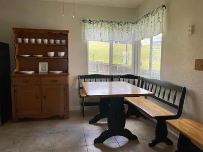 a dining room with a table and a bench and a window at Hummingbird Hill - Entire Cabin in Dunlap