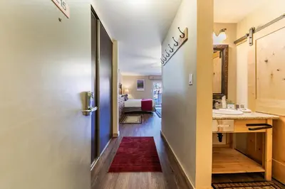 a hallway with a door to a bathroom with a sink at Charming Studio Deluxe w/kitchen #215 at Donner Lake Village in Truckee