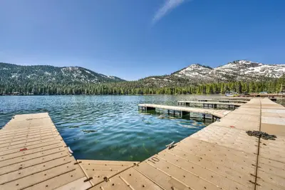 a dock on a lake with mountains in the background at Charming Studio Deluxe w/kitchen #215 at Donner Lake Village in Truckee