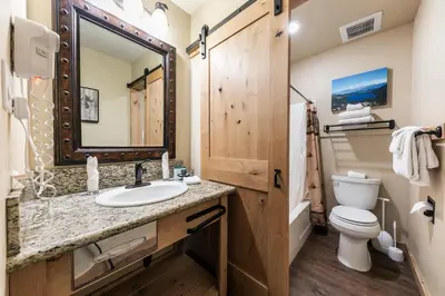 a bathroom with a sink and a toilet and a mirror at Charming Studio Deluxe w/kitchen #215 at Donner Lake Village in Truckee