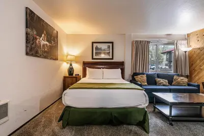 a hotel room with a bed and a couch at Cozy Studio w/Kitchenette Easily Accessible #113 at Donner Lake Village in Truckee