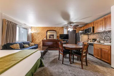 a room with a bed and a kitchen and a table at Cozy Studio w/Kitchenette Easily Accessible #113 at Donner Lake Village in Truckee