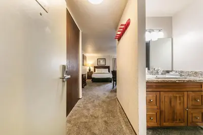 a bathroom with a sink and a bed in a room at Cozy Studio w/Kitchenette Easily Accessible #113 at Donner Lake Village in Truckee