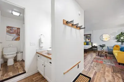 a bathroom with a sink and a toilet and a living room at Striking Queen Deluxe Studio w/Kitchenette #114 at Donner Lake Village in Truckee