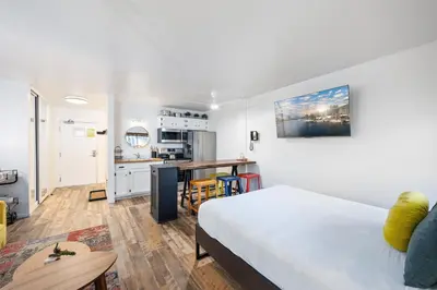 a living room with a bed and a kitchen at Striking Queen Deluxe Studio w/Kitchenette #114 at Donner Lake Village in Truckee