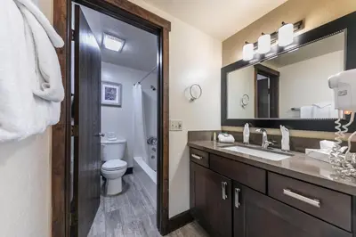 a bathroom with a sink and a toilet and a mirror at Lovely Studio w/Kitchen and Partial Lake View #122 at Donner Lake Village in Truckee