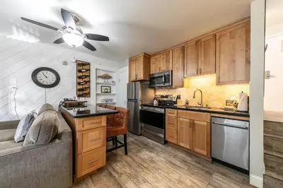 a kitchen with wooden cabinets and a clock on the wall at Partial Lake View Stunning Deluxe King Studio #125 at Donner Lake Village in Truckee