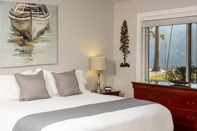 a bedroom with a bed and a painting of a boat at Partial Lake View Stunning Deluxe King Studio #125 at Donner Lake Village in Truckee