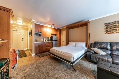 a bedroom with a bed and a couch in a room at Cozy Deluxe Studio #131 at Donner Lake Village in Truckee