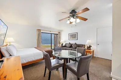 a hotel room with a bed and a table and chairs at Cozy King Studio w/Lake View #145 at Donner Lake Village in Truckee