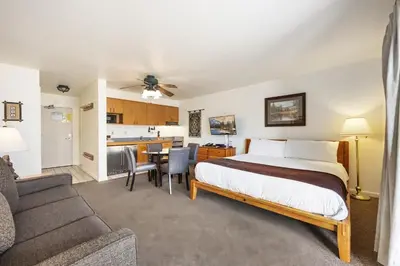 a hotel room with a bed and a kitchen at Cozy King Studio w/Lake View #145 at Donner Lake Village in Truckee
