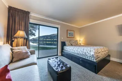 a bedroom with a bed and a couch and a window at Quaint Studio w/Lake View #146 at Donner Lake Village in Truckee