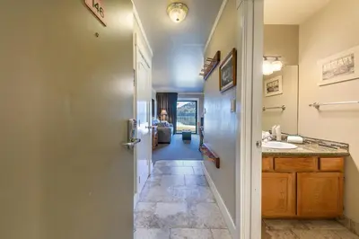 a hallway leading to a bathroom with a sink at Quaint Studio w/Lake View #146 at Donner Lake Village in Truckee