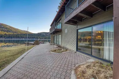 a building with a walkway next to a body of water at Quaint Studio w/Lake View #146 at Donner Lake Village in Truckee