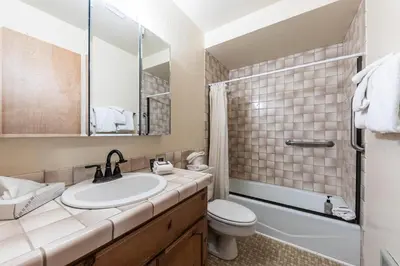 a bathroom with a sink and a toilet and a mirror at Comfortable Townhouse w/Lake View #154 at Donner Lake Village in Truckee