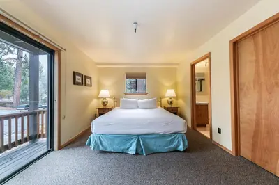 a bedroom with a bed and a balcony at Comfortable Townhouse w/Lake View #154 at Donner Lake Village in Truckee