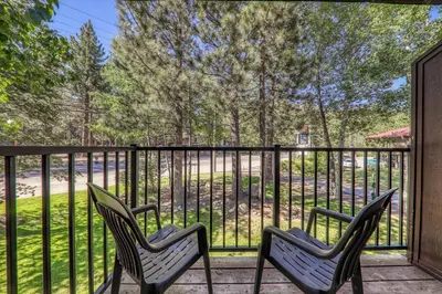 two chairs sitting on a porch with a fence at Modern Studio w/Balcony #211 at Donner Lake Village in Truckee