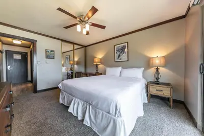 a bedroom with a white bed and a ceiling fan at Spacious Condo w/Lake View #247 at Donner Lake Village in Truckee