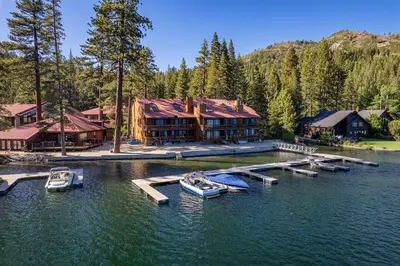 a house on a lake with boats in the water at Spacious Condo w/Lake View #247 at Donner Lake Village in Truckee