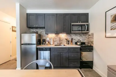 a kitchen with black cabinets and a stainless steel refrigerator at Beautiful Deluxe Studio w/Lake View #245 at Donner Lake Village in Truckee