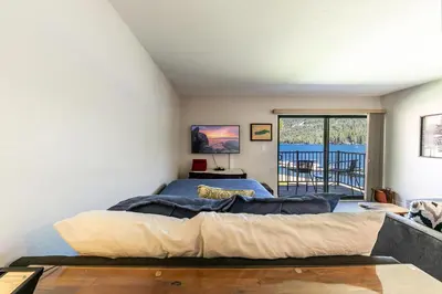 a bedroom with a large bed and a balcony at Striking Studio w/Lake View #244 at Donner Lake Village in Truckee