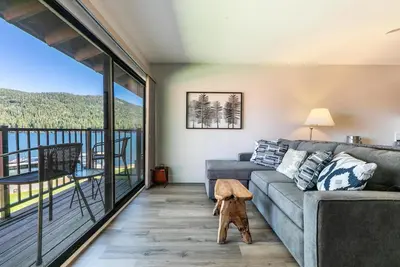 a living room with a couch and a balcony at Striking Studio w/Lake View #244 at Donner Lake Village in Truckee