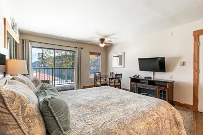 a bedroom with a bed and a flat screen tv at Beautiful Studio w/ Lake View #243 at Donner Lake Village in Truckee