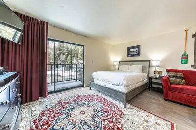 a bedroom with a bed and a red couch at Charming Queen Studio Deluxe w/Balcony #233 at Donner Lake Village in Truckee