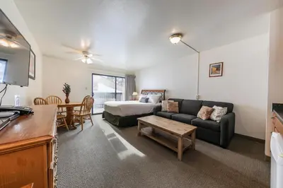 a living room with a couch and a bed and a table at Cozy Studio #226 at Donner Lake Village in Truckee