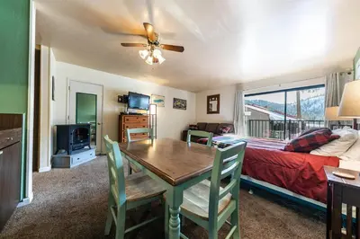 a living room with a dining room table and a bed at Cozy Studio w/Partial Lake view #224 at Donner Lake Village in Truckee
