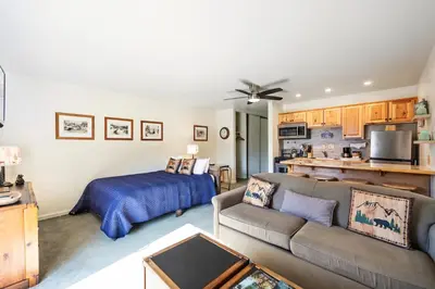 a living room with a couch and a bed at Cozy Studio w/ Partial Lake view #223 at Donner Lake Village in Truckee